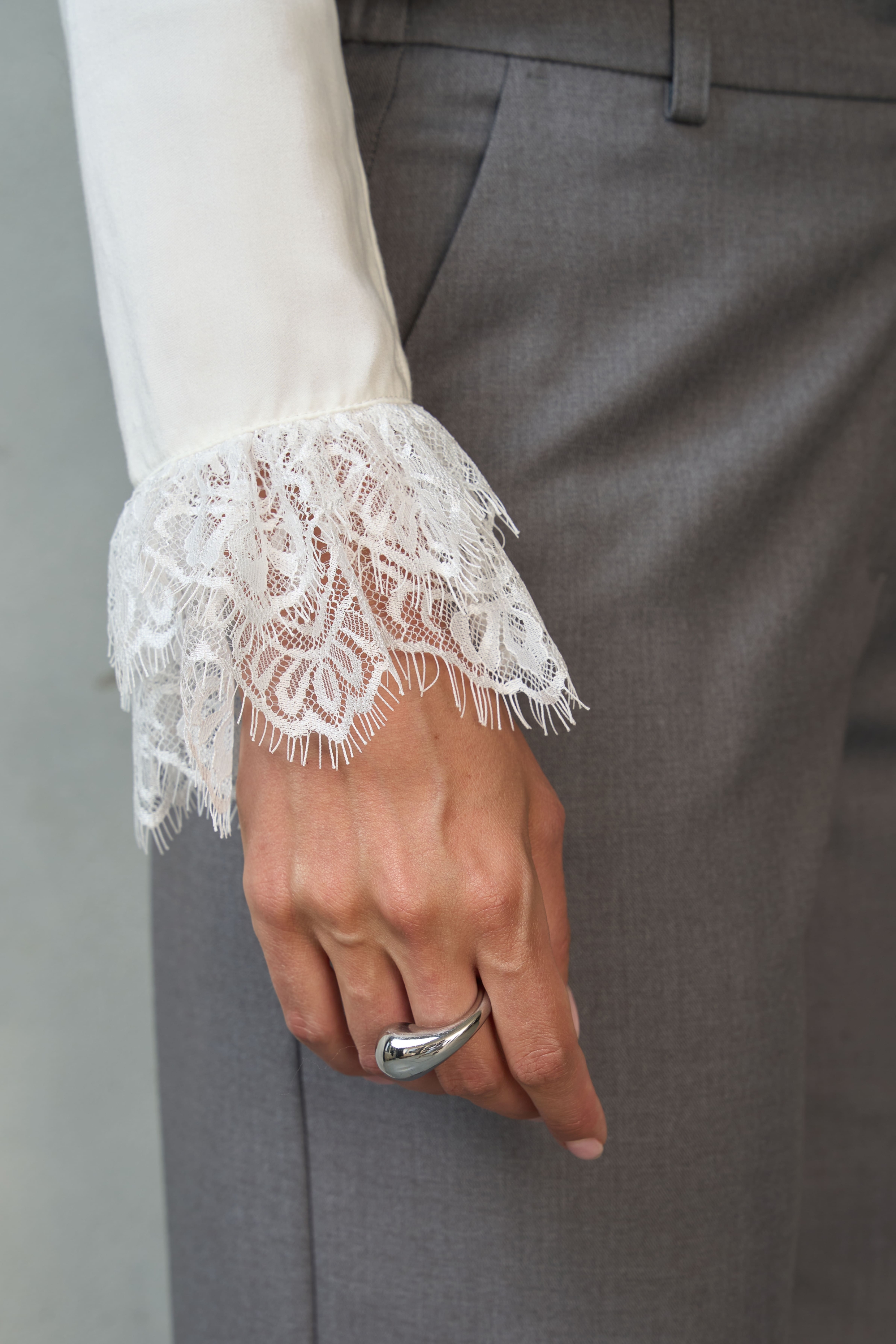 Biała bluzka z koronką LIVIA – elegancka stylizacja z szarymi spodniami