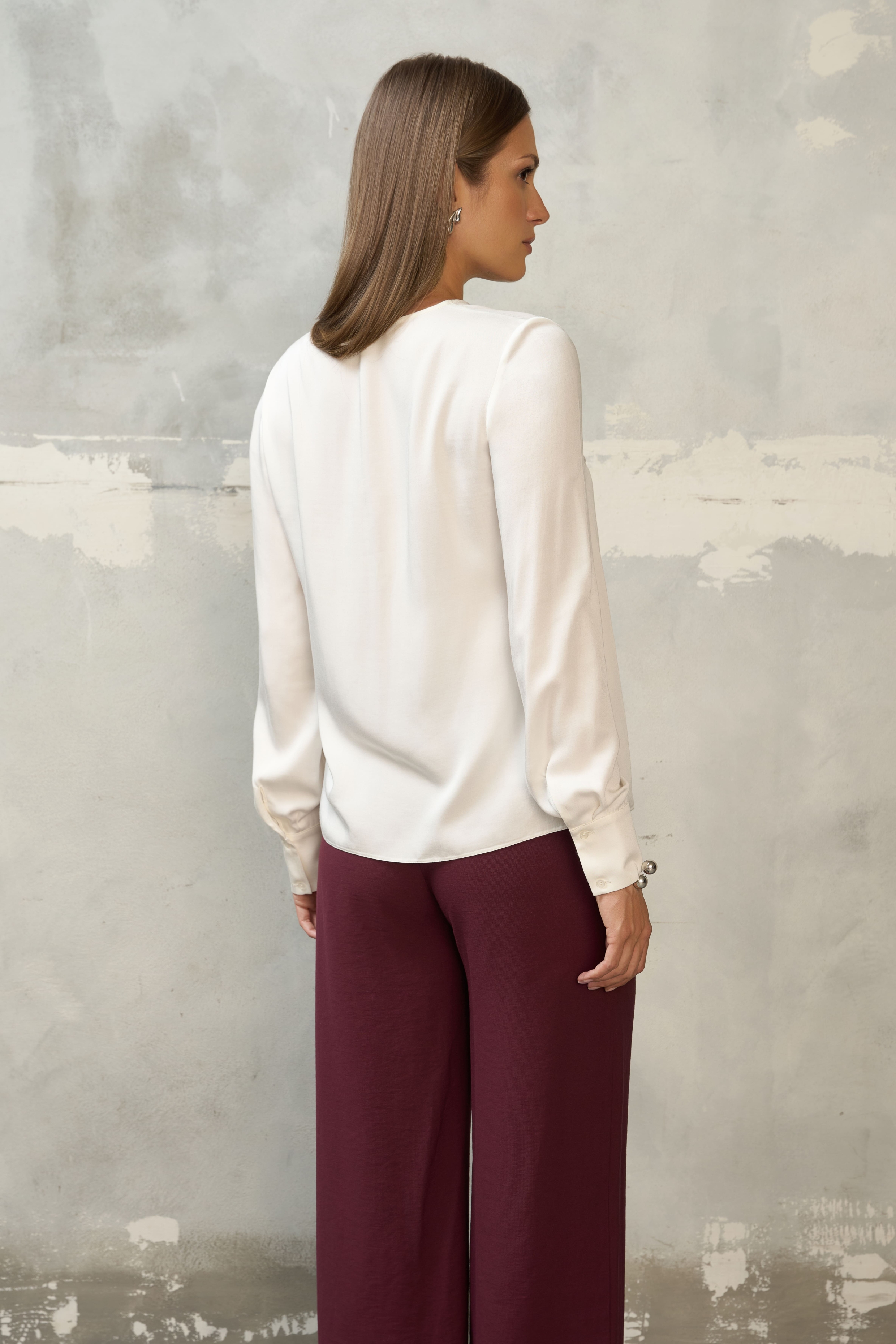 Biała bluzka damska z długim rękawem – stylizacja ze spodniami w kolorze burgundowym