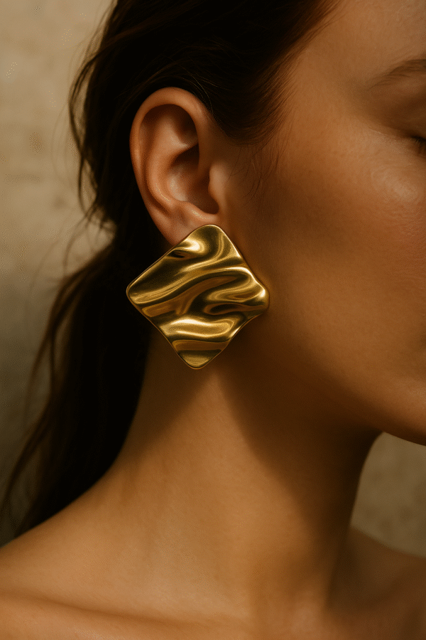 Złote kolczyki o nieregularnej formie inspirowanej stylem Bottega Veneta, eleganckie i minimalistyczne.