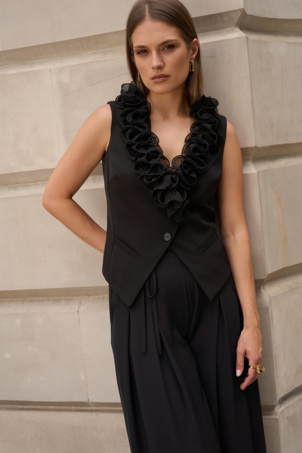 Czarna elegancka kamizelka EZURI z falbaną przy dekolcie, stylizacja z szerokimi czarnymi spodniami