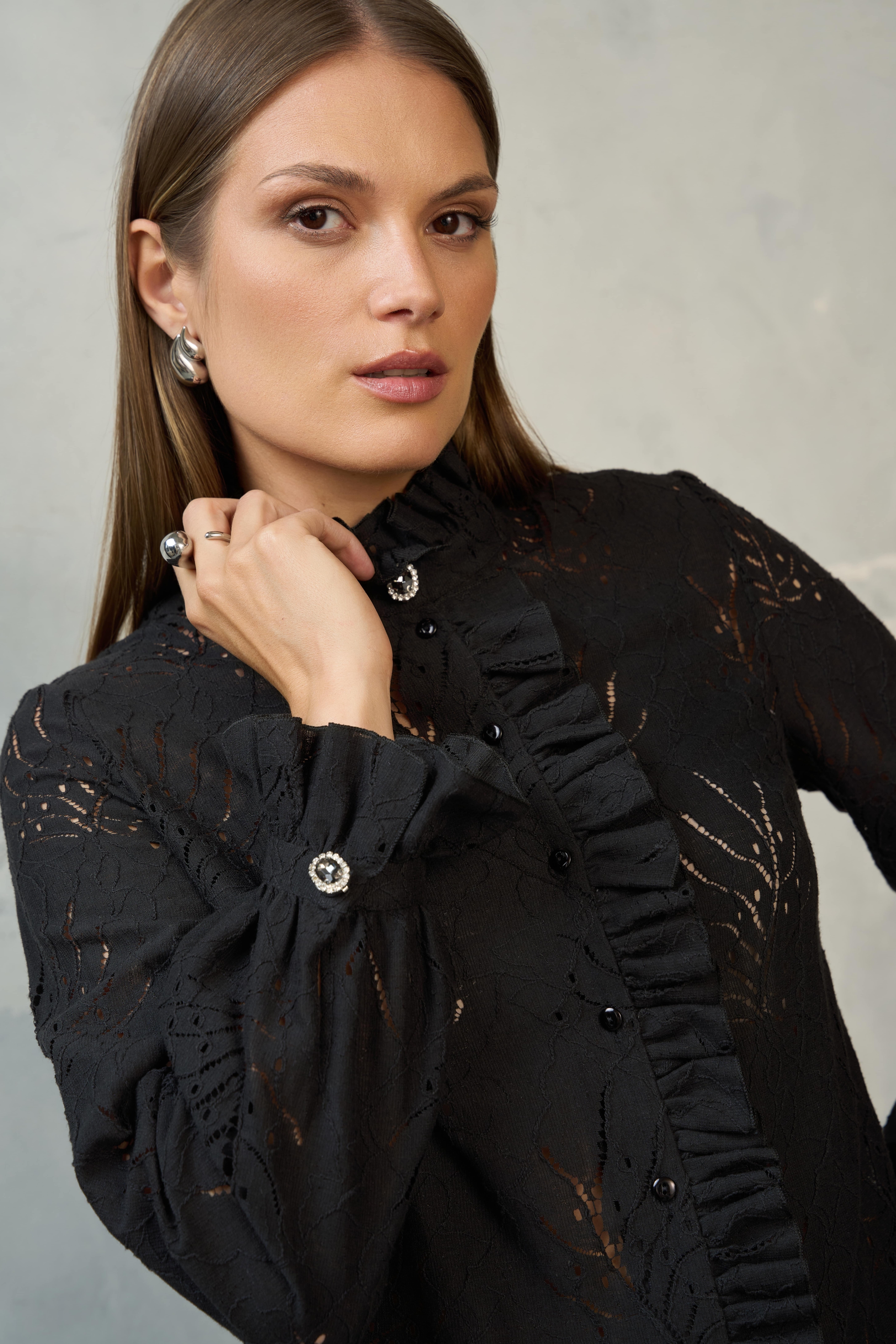 Kobieta w czarnej koronkowej bluzce EZURI