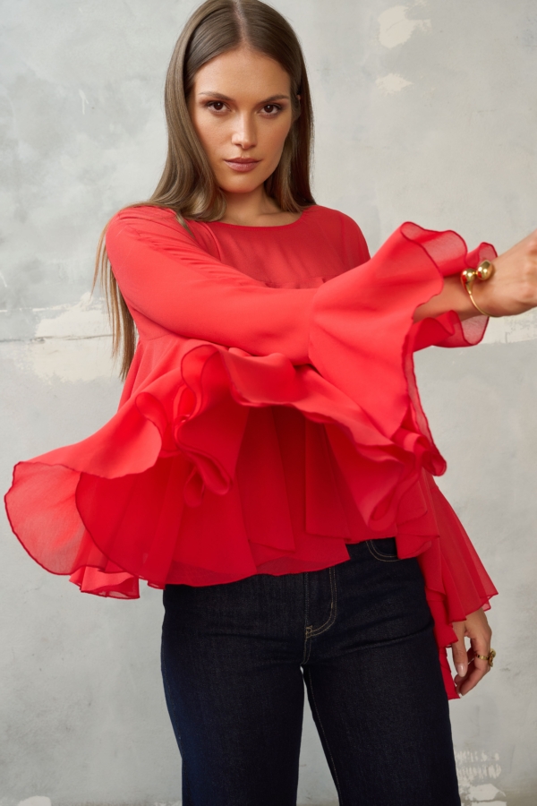 Czerwona bluzka z falbanami i szerokimi rękawami. Luźny, maskujący krój, dłuższy tył. Idealna do jeansów, na wyjście i wyjątkowe okazje.