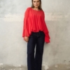 Czerwona bluzka z falbanami i szerokimi rękawami. Luźny, maskujący krój, dłuższy tył. Idealna do jeansów, na wyjście i wyjątkowe okazje.