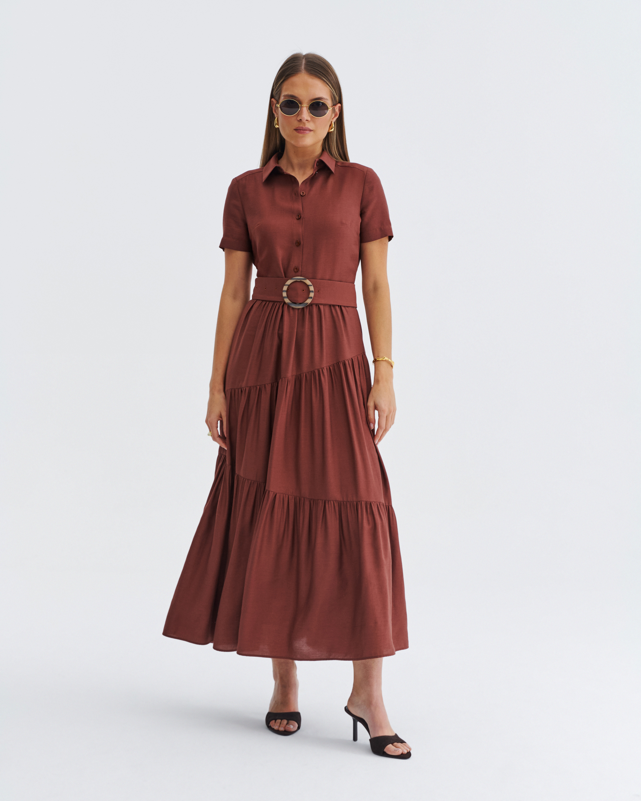 Brązowa sukienka midi z falbankami i paskiem w talii. Elegancka stylizacja.