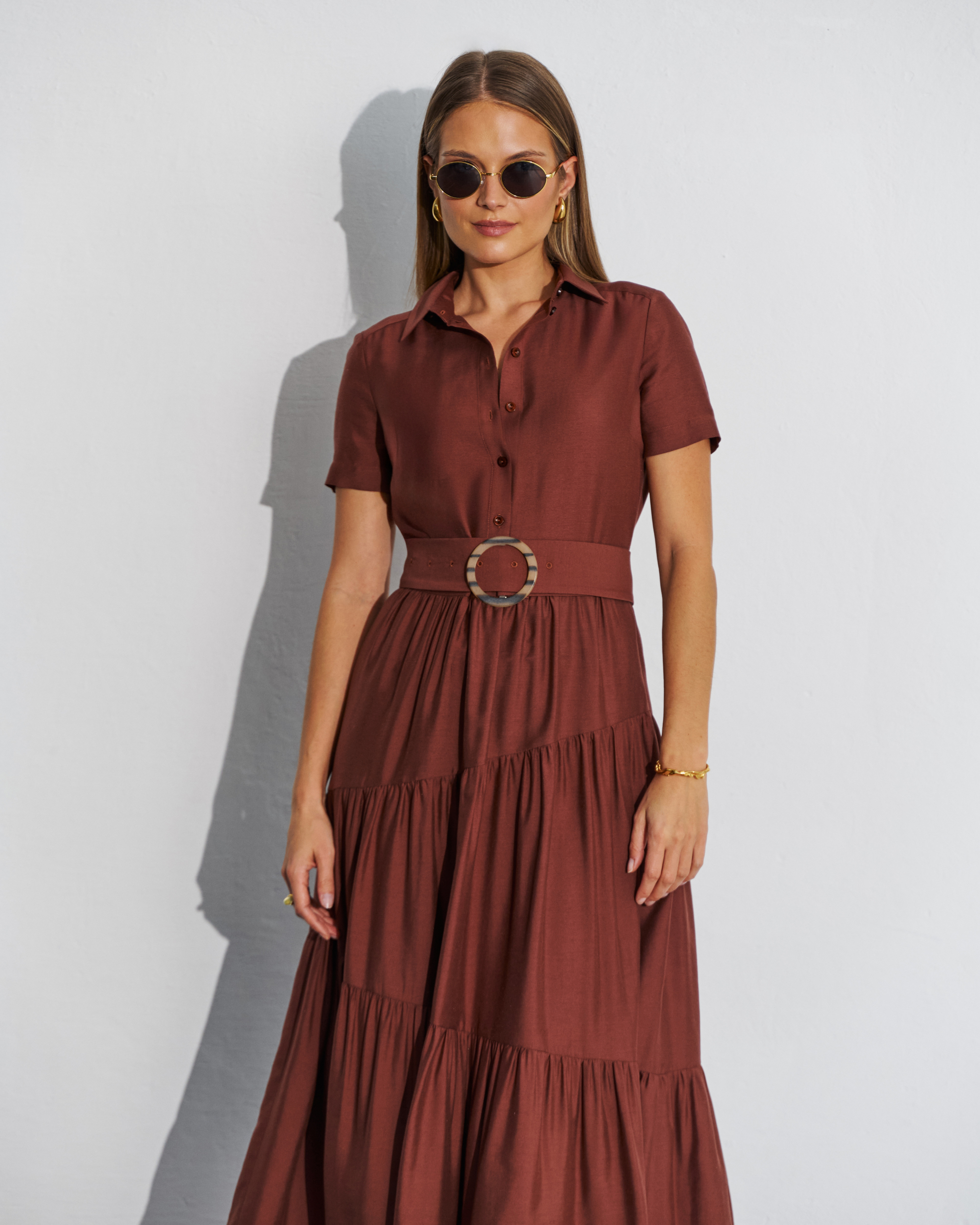 Brązowa sukienka midi z falbankami i paskiem w talii.