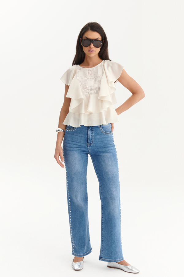 Modelka w jasnoniebieskich jeansach damskich ze srebrnymi nitami po bokach