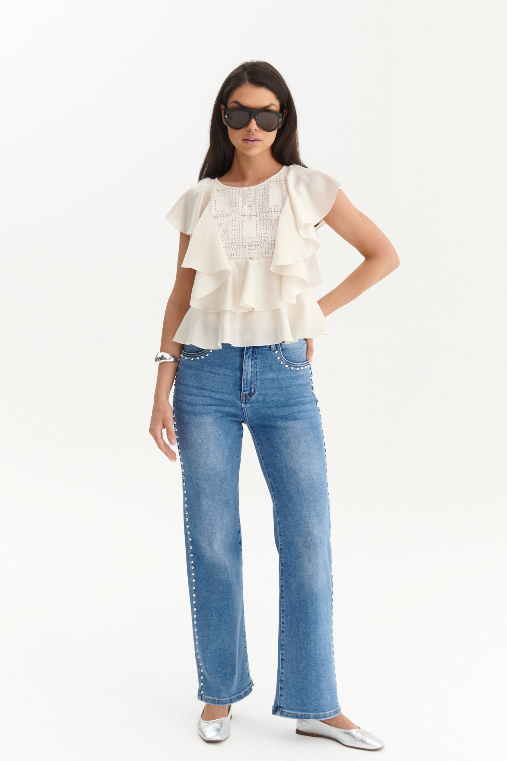 Modelka w jasnoniebieskich jeansach damskich ze srebrnymi nitami po bokach