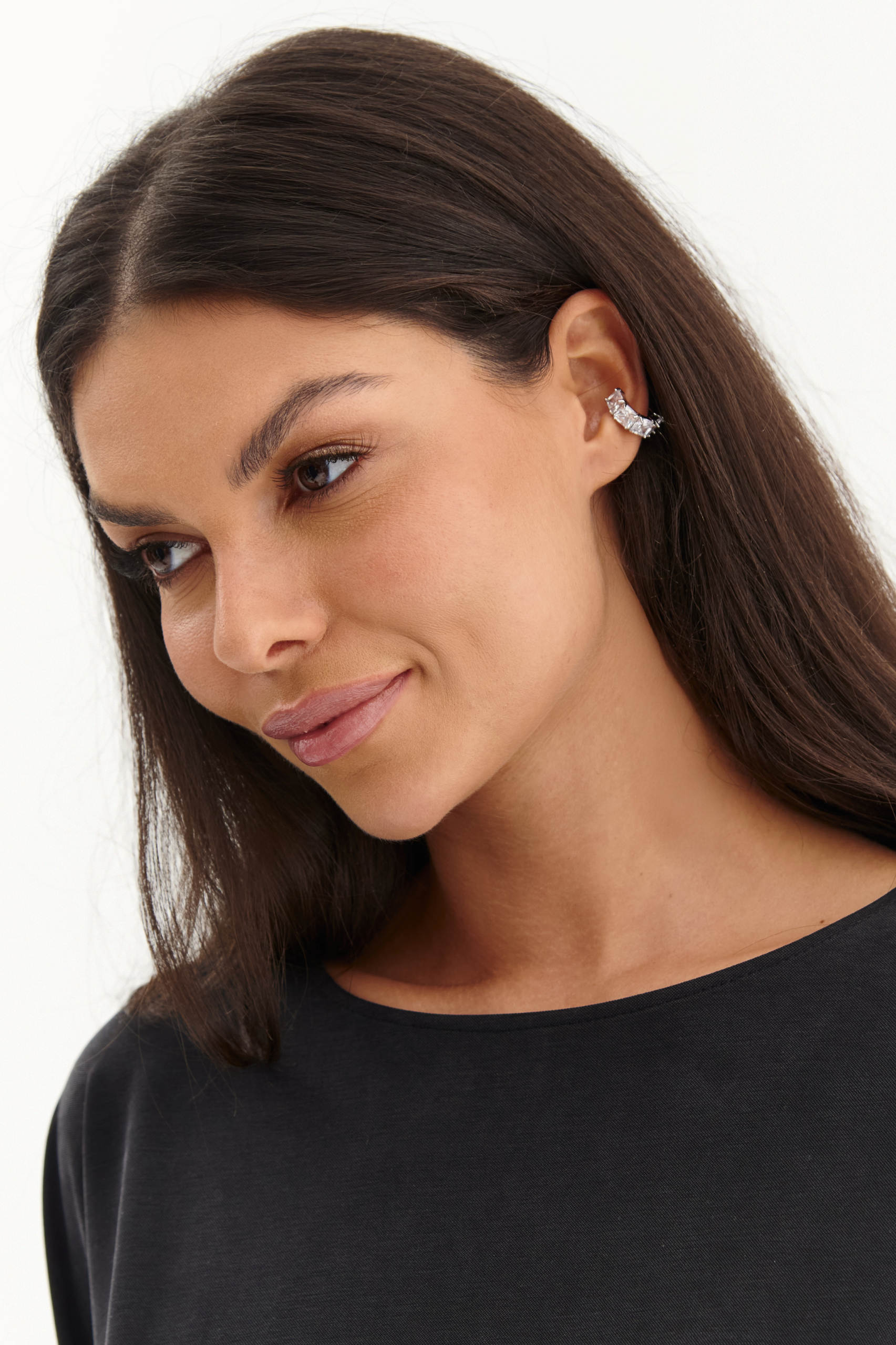 Zbliżenie na modelkę w srebrnej nausznicy z cyrkoniami