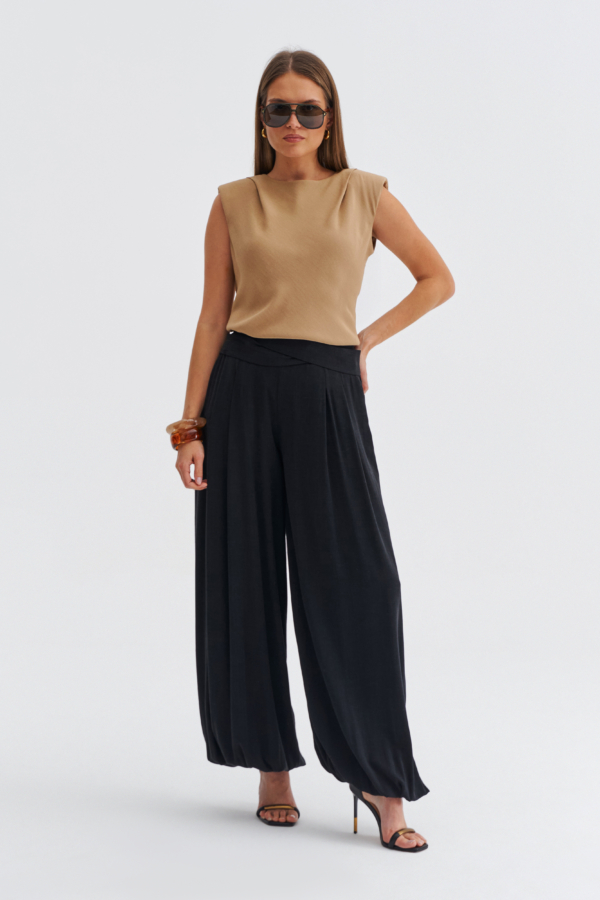 Beżowa bluzka damska bez rękawów z poduszkami na ramionach i łagodnym dekoltem.