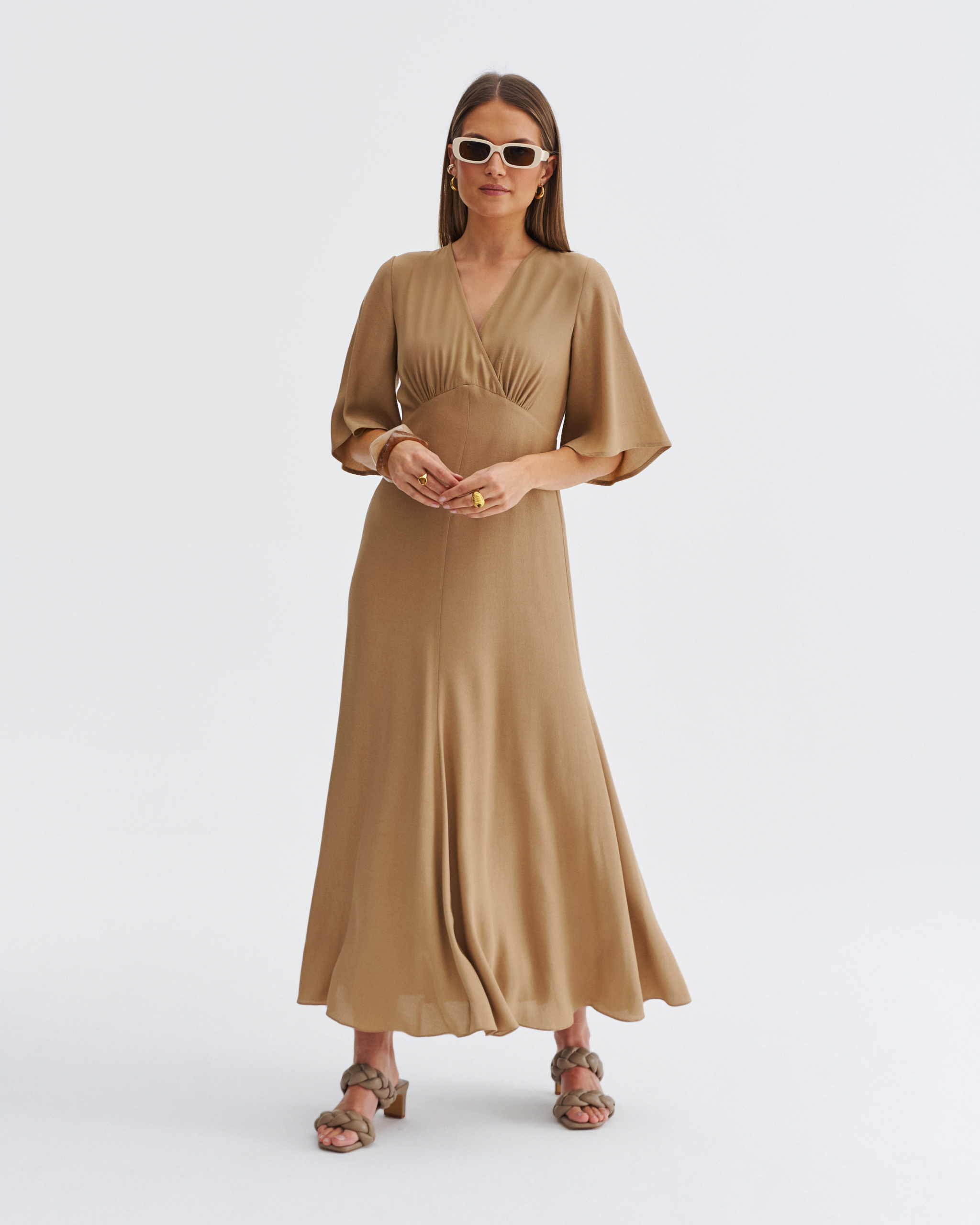Beżowa sukienka midi z kopertowym dekoltem, zwiewnymi rękawami i rozkloszowanym dołem