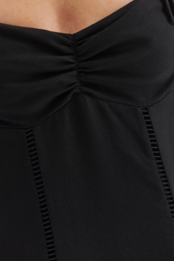 CDetal czarnej sukienki maxi z marszczeniem przy biuście i ażurowymi wstawkami.