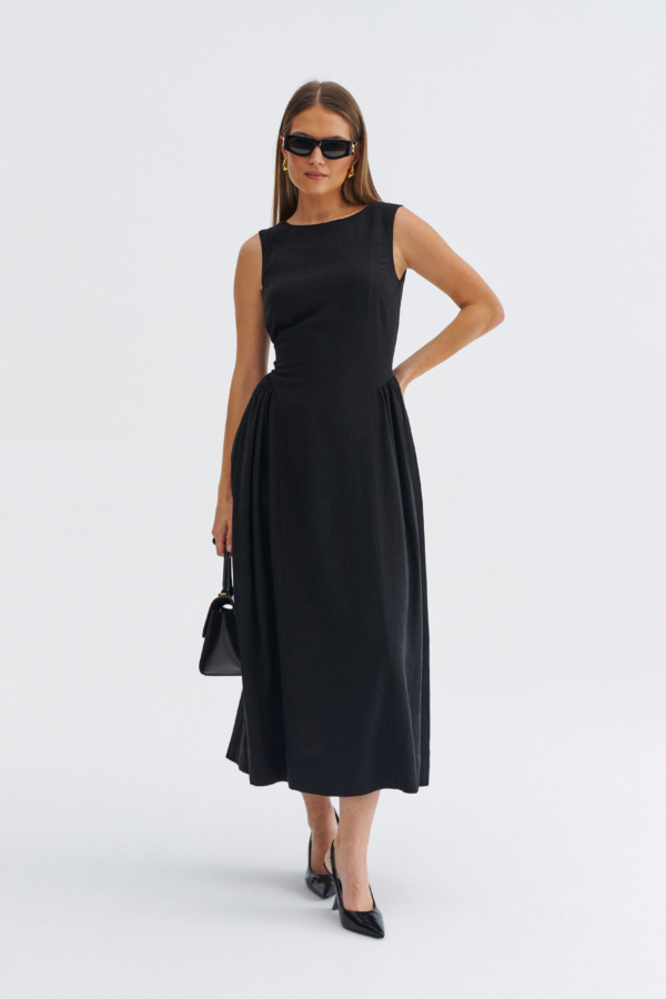 Modelka w czarnej sukience midi bez rękawów