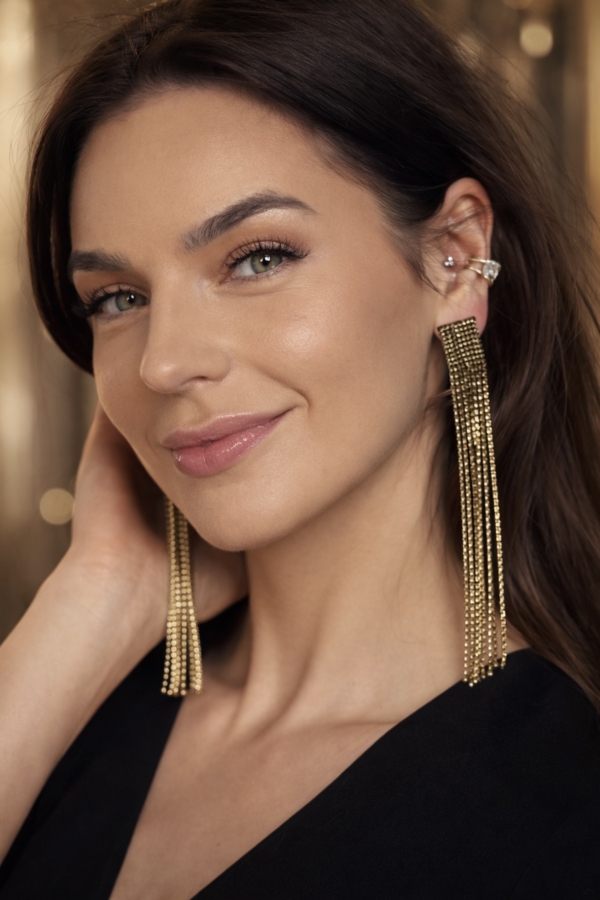 Kolczyki ze złotą obwódką i czarnym środkiem na modelce