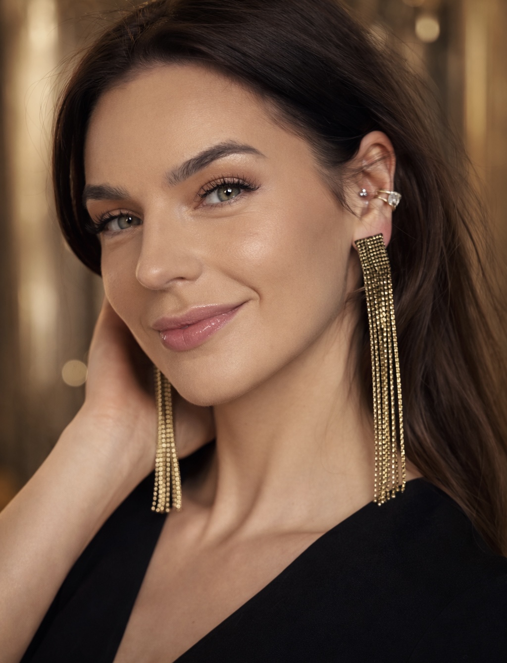 Kolczyki ze złotą obwódką i czarnym środkiem na modelce