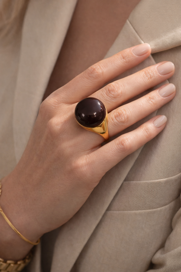 Złoty pierścionek z czekoladową emalią na dłoni