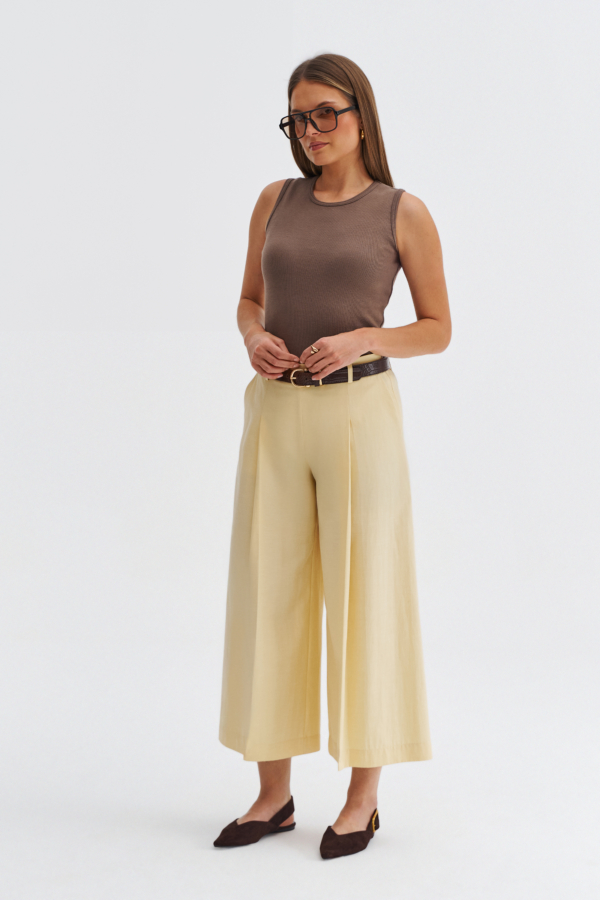 Modelka w kulotach butter yellow z szeroką nogawką