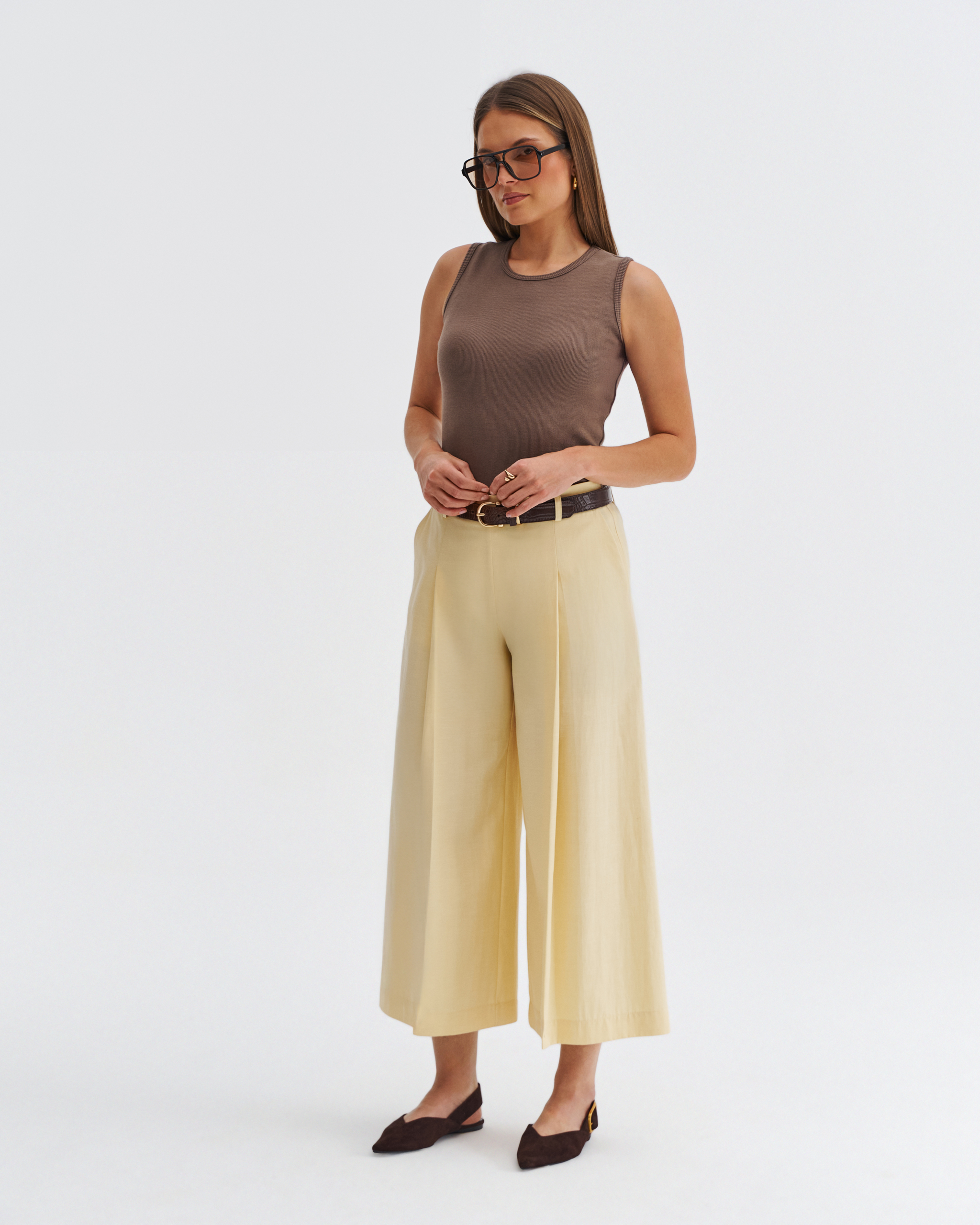 Modelka w kulotach butter yellow z szeroką nogawką